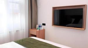 Schlafzimmer mit einem Flachbild-TV an der Wand in der Unterkunft GreenTree Inn Express Cangzhou Yunhe District Mingzhu Market in Cangzhou