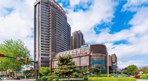a tall building in a city with a traffic light at Junyu Grand Hotel Qinhuangdao in Qinhuangdao