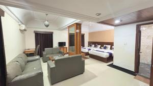 una sala de estar con un sofá y una cama en Hotel Chetan International, en Bangalore 236 fotos más