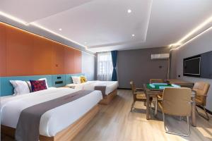Jun Select Hotel Hubei Wuhan Hanjiang District Liuduqiao Metro Station في ووهان: غرفة فندقية بسريرين وغرفة طعام