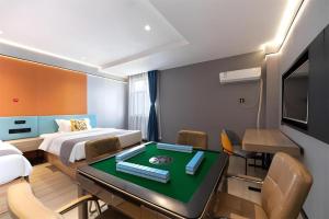 Jun Select Hotel Hubei Wuhan Hanjiang District Liuduqiao Metro Station في ووهان: غرفة فندق بها سرير وطاولة وكراسي