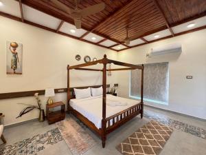 ein Schlafzimmer mit einem Himmelbett in einem Zimmer in der Unterkunft Le Terra Luxury VIP Resort - TIE in Puducherry + 90 Fotos