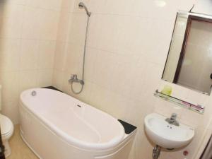 Un baño con bañera, lavabo e inodoro. en Kangaroo Hostel, en Hanói