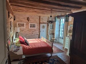 a bedroom with a bed and a brick wall at Chambres d'Hôtes L'Ecu in Preuilly-sur-Claise
