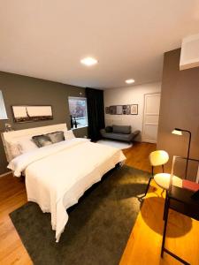 a bedroom with a large white bed and a couch at Beautiful house close to center in Gothenburg