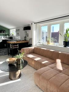 a living room with a brown couch and a table at Beautiful house close to center in Gothenburg