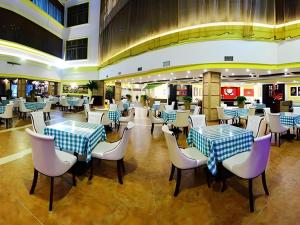 un restaurant avec des tables et des chaises bleues et blanches dans l'établissement Vienna International Hotel Nanning East Station, à Nanning