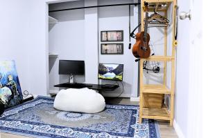 ein Wohnzimmer mit einer Gitarre und einem Hocker in der Unterkunft Charming Cozy Stay In Heart Of St Albans in St Albans