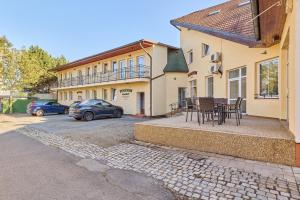 a house with a table and chairs in a driveway at Garnet Penzion in Olomouc