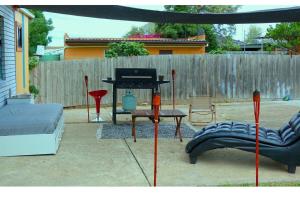 einen Hinterhof mit einem Grill, einer Couch und einem Tisch in der Unterkunft Charming Cozy Stay In Heart Of St Albans in St Albans