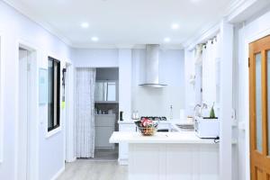 eine weiße Küche mit einer Theke und einem Waschbecken in der Unterkunft Charming Cozy Stay In Heart Of St Albans in St Albans