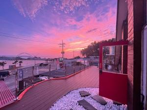 - une vue sur un bâtiment avec un coucher de soleil en arrière-plan dans l'établissement LaniKai Full oceanview stay, à Namae-ri