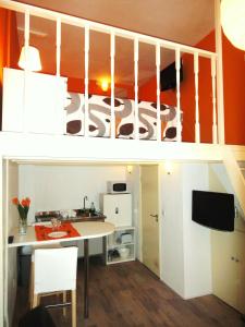 Habitación pequeña con cocina y escalera con escritorio. en Orange Suite Studio, en Ámsterdam