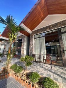 a patio with a table and chairs on a house at Tràng An Riverbank Homestay in Nguyên Ngoại