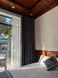a bedroom with a bed and a large window at Tràng An Riverbank Homestay in Nguyên Ngoại