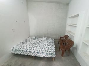 a bedroom with a bed and two chairs at Hariom Homestay in Barwa Sāgar