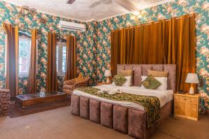 a bedroom with a large bed and floral wallpaper at Heritage Bungaow in Srinagar