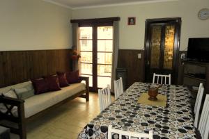 uma sala de estar com um sofá e uma mesa em Amapolas Huéspedes em Tandil