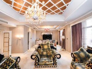 a living room with chairs and a chandelier at Qingdao Danube International Hotel in Qingdao