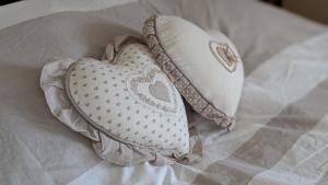 zwei Kissen in Herzform auf einem Bett in der Unterkunft Les Perles du Ried - Gîte 208 in Boofzheim