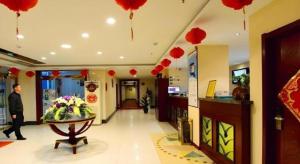 a man walking through a lobby with red balloons at GreenTree Inn Shandong Yantai Penglai Pavilion Bus station Express Hotel in Penglai