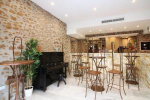 a bar with a piano in a room with stools at New Generation Hostel Rome Center in Rome