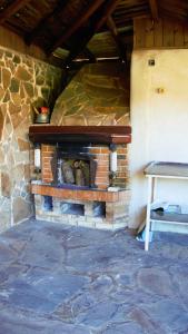 una chimenea de ladrillo en una habitación con mesa en Atanasovi House, en Shkorpilovtsi