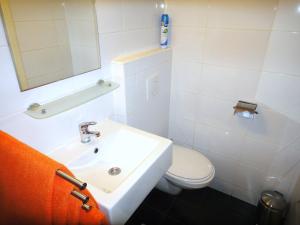 Baño blanco con lavabo y aseo en Orange Suite Studio, en Ámsterdam