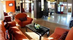 a lobby with a couch and a chair and a table at Day Hotel Khon Kaen in Khon Kaen