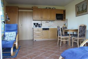 eine Küche mit Holzschränken und einem Tisch und Stühlen in der Unterkunft Ferienhaus am See - b44952 in Blankensee