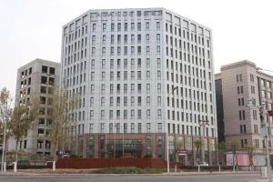 ein hohes weißes Gebäude vor einigen Gebäuden in der Unterkunft Lavande Hotels Tianjin Huaming Binhai International Airport in Tianjin
