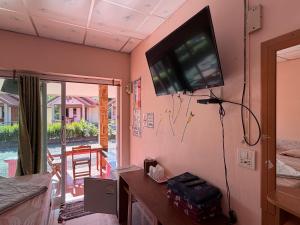 a living room with a flat screen tv on the wall at ปลาตอง รีสอร์ท in Chao Lao Beach +17 photos