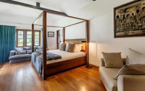 une chambre avec un lit à baldaquin et un canapé dans l'établissement Craigbank Nuwaraeliya, à Nuwara Eliya