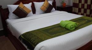 ein grünes Handtuch auf einem Bett in der Unterkunft Phetphaylin Hotel in Ban Talai + 52 Fotos