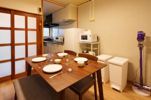 a kitchen with a wooden table with chairs and a microwave at 畳庵嵐山 in Kyoto