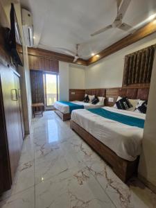 Una habitación de hotel con dos camas y un televisor. en Hotel Signature, en Ahmedabad