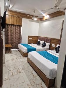 dos camas en una habitación con dos camas sidx sidx sidx sidx en Hotel Signature, en Ahmedabad
