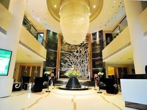 a lobby with a fountain in the middle of a building at Qingdao Minlian Kaixuan Hotel in Laoshan