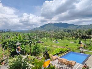 a resort with a swimming pool and mountains in the background at Bukit Luah Sidemen in Sidemen
