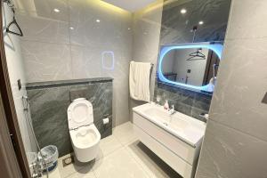 a bathroom with a toilet and a sink and a mirror at Luxury Studio at Monal Murree with Mountain Views in Murree