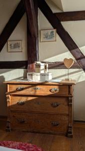 a wooden dresser in a room with a bed at Les Perles du Ried - Gîte 209 in Boofzheim