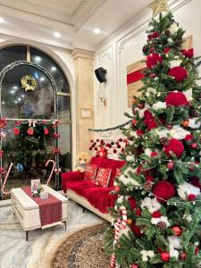 ein Weihnachtsbaum in einem Wohnzimmer mit einer roten Couch in der Unterkunft Thuận Phát Hotel in Soc Trang