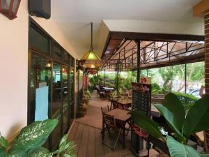 an outdoor patio with tables and chairs and plants at Rayong Lanna Hotel in Ban Noen Phra