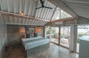 a bedroom with a bed in a room with windows at Light The Path Bali in Uluwatu +95 photos