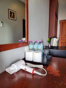 eine Theke mit Rollen Papierhandtüchern und Wasserflaschen in der Unterkunft The Rest Phuket in Phuket