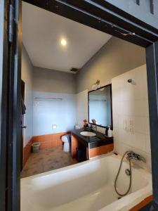 ein großes Badezimmer mit Badewanne und Waschbecken in der Unterkunft The Rest Phuket in Phuket + 30 Fotos