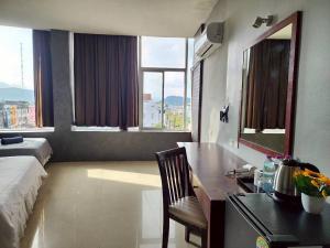 ein Hotelzimmer mit einem Bett und einem Schreibtisch mit einem Schreibtisch in der Unterkunft The Rest Phuket in Phuket