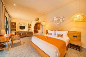 a bedroom with a large bed and a dining room at Neola Amazing 5 BR Private Pool Villa ZN365 in Tanah Lot