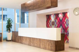 un comptoir dans une pièce avec une horloge sur un mur dans l'établissement Clarion Suites Guatemala City, à Guatemala