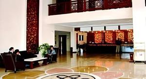 eine Lobby mit Menschen, die in Stühlen in einem Gebäude sitzen in der Unterkunft Shangri-La Original Density Hotel in Shangri-La